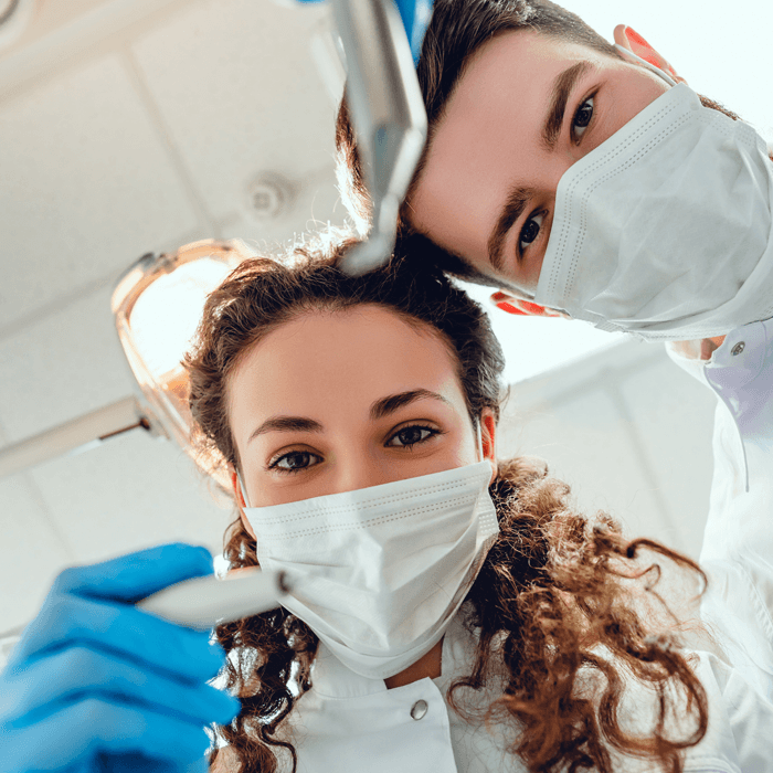 Dentysta i higienistka pracujący w gabinecie stoamtologicznym