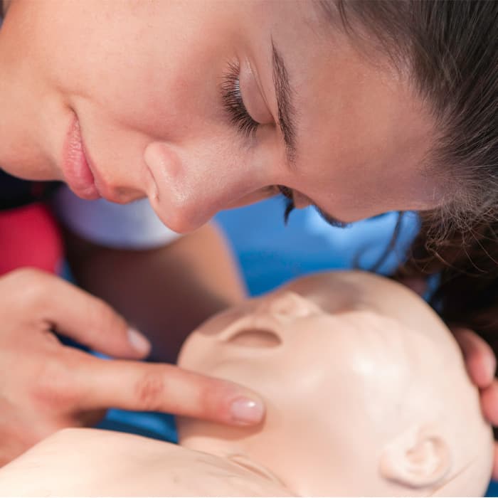 Osoba sprawdza przytomność poszkodowanego 