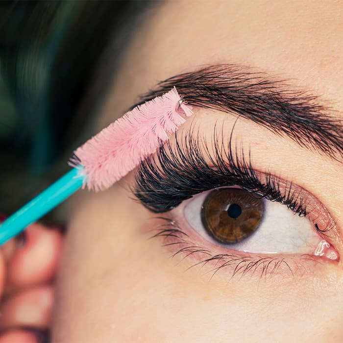 Kobieta w czasie zabiegu przedłużania rzęs
