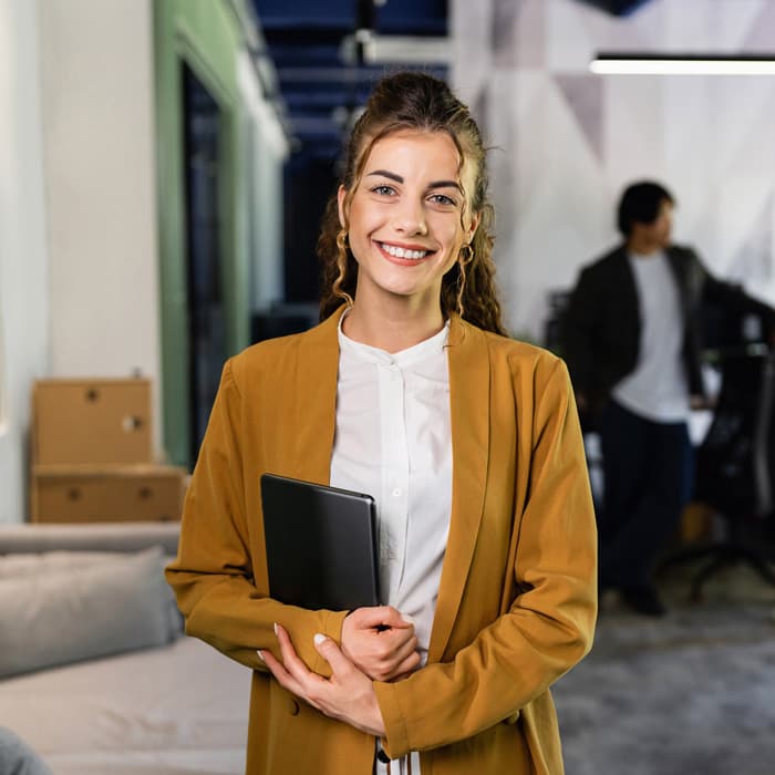 Kobieta stoi z tabletem w biurze 