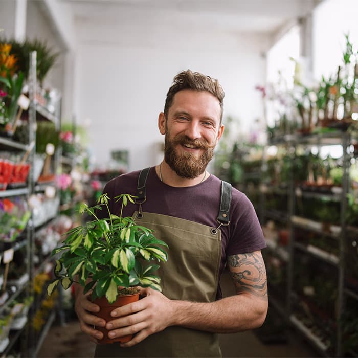 mężczyzna z rośliną ogrodową w sklepie