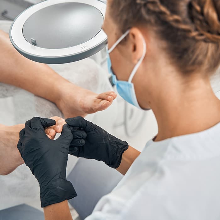 Podolog wykonuje zabieg 