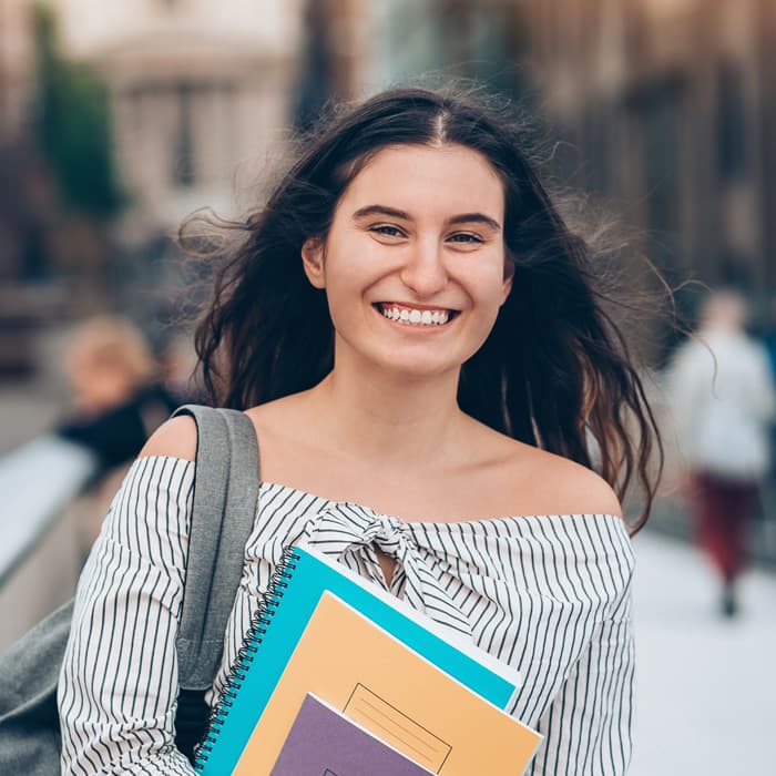 Kobieta niesie książki z języka polskiego