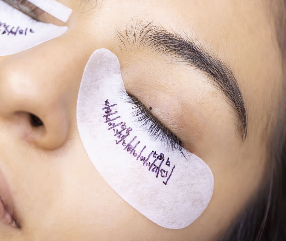 Kobieta w czasie zabiegu przedłużania rzęs