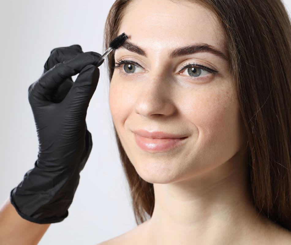 Specjalistka wykonuje zabieg przedłużenia rzęs oraz liftingu brwi