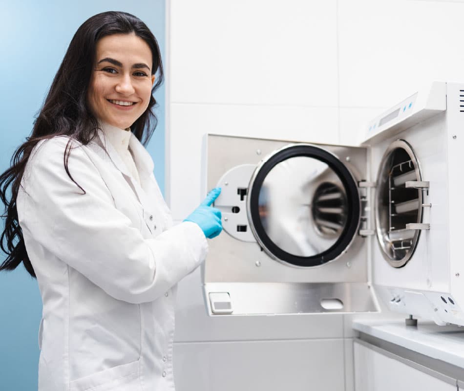 kobieta obsługuje urządzenie do sterylizacji