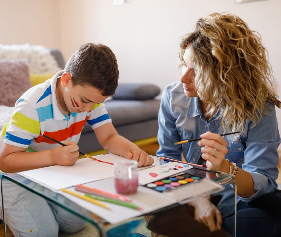 terapeuta zajęciowy i dziecko malują