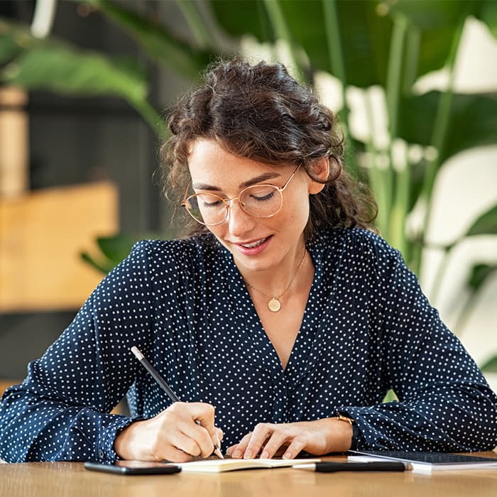 Osoba pisze w zeszycie